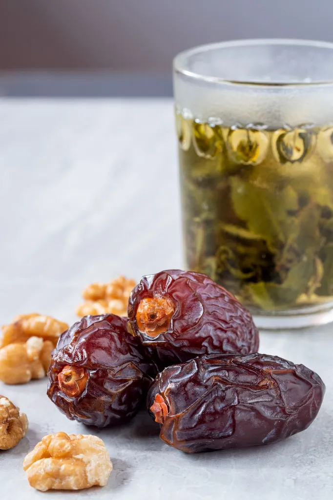 large-date-fruits-medjool-with-walnut-tea-glass-marble-floor.webp